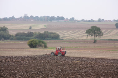 Tractor plowing with land with Field Strips in the background