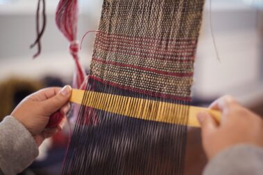 Volunteer weaving at flax workshop