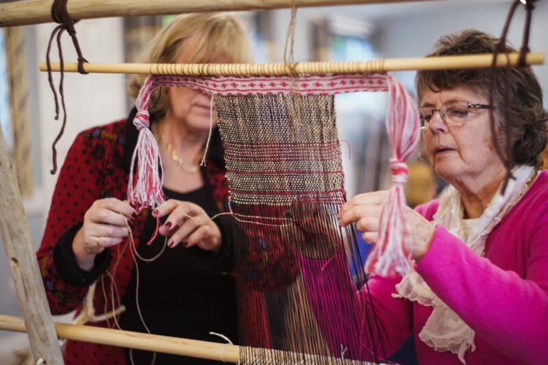 Weavers Weaving Volunteers weaving during flax workshop